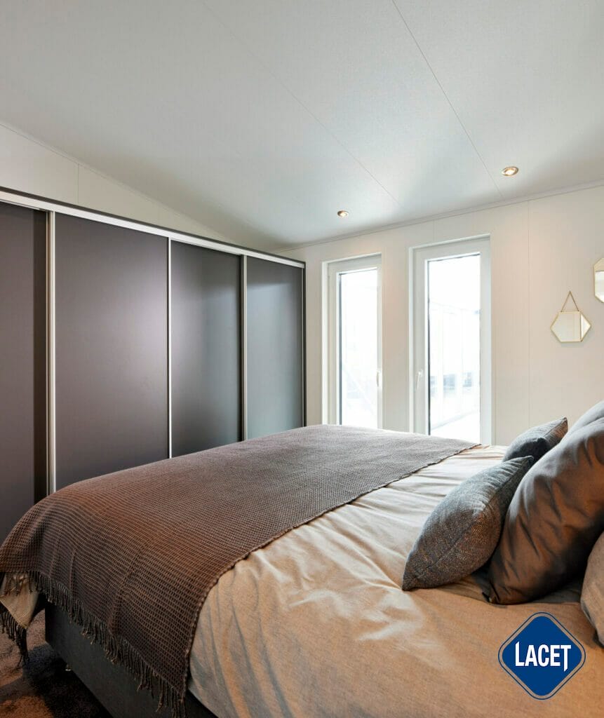 Schlafzimmer mit Doppelbett und viel Stauraum im LACET Mobilheim